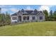 Striking stone and gray siding with a manicured lawn adds curb appeal to this home at 7517 Lancaster Hwy # 5, Waxhaw, NC 28173