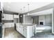 A bright, modern kitchen with white cabinets, a central island with pendant lights, and stainless steel appliances at 7517 Lancaster Hwy # 5, Waxhaw, NC 28173