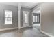 Inviting living room showcasing light wood floors, large windows, and an open doorway leading to a carpeted room at 7517 Lancaster Hwy # 5, Waxhaw, NC 28173