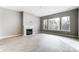 Bright living room with a fireplace, three windows, and light colored vinyl flooring at 7517 Lancaster Hwy # 5, Waxhaw, NC 28173