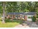 Well-kept brick home boasts lush green lawn, mature trees, and a classic, timeless architecture at 844 Fieldstone Rd, Mooresville, NC 28115