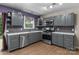 Updated kitchen features stainless steel appliances, gray cabinets, and stylish subway tile backsplash at 844 Fieldstone Rd, Mooresville, NC 28115