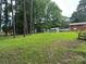 Lush green backyard with seating, outbuilding, and mature trees at 8524 Anette Ave, Mint Hill, NC 28227