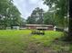 Sprawling backyard with mature trees, outbuilding, deck and seating areas at 8524 Anette Ave, Mint Hill, NC 28227