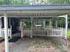 Covered carport with white picket fence, offering protected parking at 8524 Anette Ave, Mint Hill, NC 28227