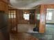 View of the dining room with wood paneling, built-in cabinets, and seamless flow into the living room at 8524 Anette Ave, Mint Hill, NC 28227