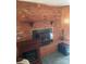 Brick fireplace featuring a rustic wood mantle and raised brick hearth, with an additional electric fireplace nearby at 8524 Anette Ave, Mint Hill, NC 28227