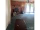 Living room with a brick fireplace, wood paneling, carpeted floors, and access to outdoor french doors at 8524 Anette Ave, Mint Hill, NC 28227
