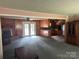 Open concept living room featuring a brick fireplace, French doors, and seamless flow into the kitchen at 8524 Anette Ave, Mint Hill, NC 28227