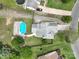 Aerial view of a property with a blue pool and wooden deck, surrounded by lush greenery and neighboring homes at 8540 Indian Summer Trl, Harrisburg, NC 28075