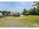 Expansive backyard featuring a wooden deck, tiki bar, above ground pool, and mature trees at 8540 Indian Summer Trl, Harrisburg, NC 28075