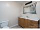 Bathroom features a wood vanity with drawers, a white sink, and a modern framed mirror at 8540 Indian Summer Trl, Harrisburg, NC 28075