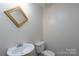 Powder room features a pedestal sink, classic fixtures, and a gold framed mirror at 8540 Indian Summer Trl, Harrisburg, NC 28075