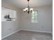 Open dining room with modern chandelier, wood floors, and view into kitchen area at 8540 Indian Summer Trl, Harrisburg, NC 28075