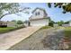 Two-story home featuring a two-car garage, driveway, and adjacent gravel area at 8540 Indian Summer Trl, Harrisburg, NC 28075