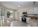 Bright kitchen features stainless steel appliances, granite countertops, sleek floors, and ample lighting at 8540 Indian Summer Trl, Harrisburg, NC 28075