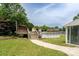 A backyard with a pool, deck, tiki hut, and mature landscaping creates a private backyard oasis at 8540 Indian Summer Trl, Harrisburg, NC 28075