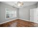Bedroom with hardwood floors, a ceiling fan, and a window for natural lighting at 8731 Coralbell Ln, Charlotte, NC 28213
