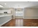 Dining room featuring hardwood floors, a chandelier, and open access to the kitchen area at 8731 Coralbell Ln, Charlotte, NC 28213