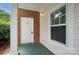 Inviting covered entryway with brick accents, white door, and a bright window at 8731 Coralbell Ln, Charlotte, NC 28213