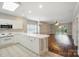 Bright kitchen featuring white cabinets, long countertops, and an open layout to the living area at 8731 Coralbell Ln, Charlotte, NC 28213