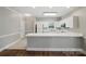 Clean kitchen with white cabinetry, gray walls, and a long countertop with a breakfast bar at 8731 Coralbell Ln, Charlotte, NC 28213