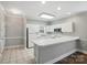Well-lit kitchen with white cabinetry, tile floors, and a convenient breakfast bar at 8731 Coralbell Ln, Charlotte, NC 28213