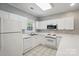 Well-equipped kitchen featuring white appliances, countertops, and tile flooring at 8731 Coralbell Ln, Charlotte, NC 28213