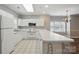 Spacious kitchen with white cabinets and appliances, offering seamless flow to the dining area at 8731 Coralbell Ln, Charlotte, NC 28213