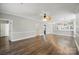 Spacious living area offering hardwood floors, ceiling fan, and open layout to kitchen at 8731 Coralbell Ln, Charlotte, NC 28213
