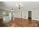 Open living space featuring hardwood floors, a ceiling fan, a chandelier, and access to a patio at 8731 Coralbell Ln, Charlotte, NC 28213