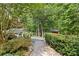 Private backyard retreat featuring lush landscaping, brick walkway and shed at 9918 Windrow Dr, Indian Trail, NC 28079