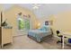 This bedroom offers a ceiling fan, neutral carpet, and a window with forest views at 9918 Windrow Dr, Indian Trail, NC 28079