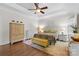 This bedroom features a ceiling fan, a tray ceiling, hardwood floors, and a decorative wall hanging at 9918 Windrow Dr, Indian Trail, NC 28079