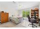 Well-lit bedroom featuring a ceiling fan, large window, and a desk area with built-in shelving at 9918 Windrow Dr, Indian Trail, NC 28079