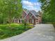 Charming two-story brick home with manicured lawn, mature trees, and inviting driveway at 9918 Windrow Dr, Indian Trail, NC 28079