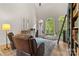 Cozy living room with large windows offering views to the garden and a floor-to-ceiling bookcase with ladder at 9918 Windrow Dr, Indian Trail, NC 28079