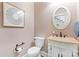 Charming powder room featuring detailed vanity, oval mirror, and decorative wall art at 9918 Windrow Dr, Indian Trail, NC 28079