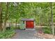 A shed with red doors amidst green trees at 9918 Windrow Dr, Indian Trail, NC 28079