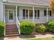 Inviting front porch with brick steps and white railings and manicured shrubs at 1028 Swaying Oats Dr, York, SC 29745