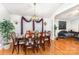 Dining room with wooden table set for a meal, chandelier, and view into living room at 1076 Braxton Dr, Concord, NC 28025