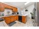 Spacious kitchen boasts wood cabinets, neutral countertops and backsplash, and modern appliances at 1076 Braxton Dr, Concord, NC 28025