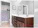 A bathroom with double sinks, brown cabinets, and stylish lighting offers a functional and elegant design at 10911 Skymont Dr, Huntersville, NC 28078