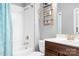 A white tiled bathtub and wooden vanity with a white sink creates a stylish, modern bathroom at 10911 Skymont Dr, Huntersville, NC 28078