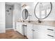 Modern bathroom with a double vanity, herringbone floors, and stylish lighting fixtures at 10911 Skymont Dr, Huntersville, NC 28078