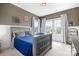 A bedroom with a gray bed, lots of light from windows, and colorful artwork, perfect for relaxation and creativity at 10911 Skymont Dr, Huntersville, NC 28078