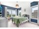 A cozy room with large windows lets in lots of light with a green bedspread and wooden wall panels at 10911 Skymont Dr, Huntersville, NC 28078