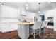 Kitchen with grey island, white cabinets, stainless appliances, and hardwood floors at 10911 Skymont Dr, Huntersville, NC 28078