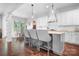 Bright kitchen with white cabinets, gray island with bar seating, and hardwood floors at 10911 Skymont Dr, Huntersville, NC 28078