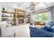 Cozy living room featuring a stone fireplace, open shelves, coffered ceiling, and abundant natural light at 10911 Skymont Dr, Huntersville, NC 28078
